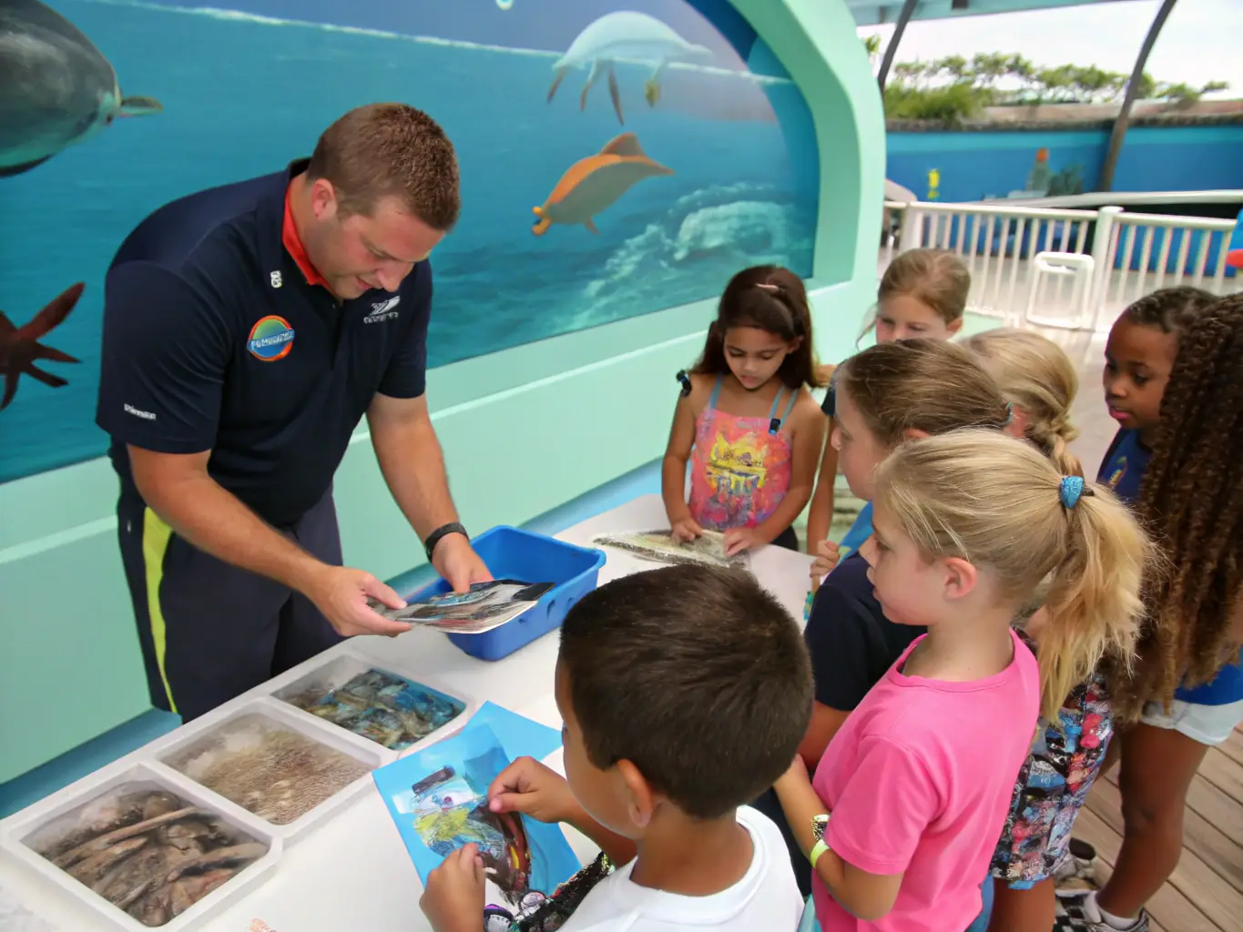 A group of children participating in a guided tour of the Chenal d'Ors ecosystem, led by a LE CHENAL D'ORS educator, focusing on local marine life and conservation efforts.